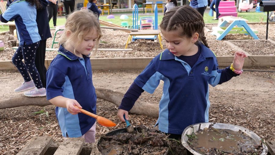 Two ELC children playing with mud kitchen