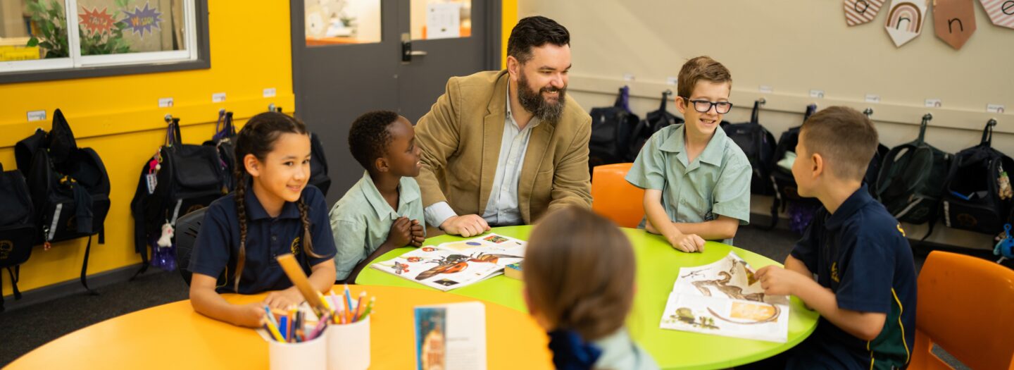 Students reading with Principal