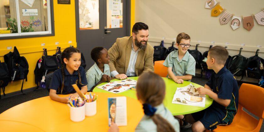 Students reading with Principal